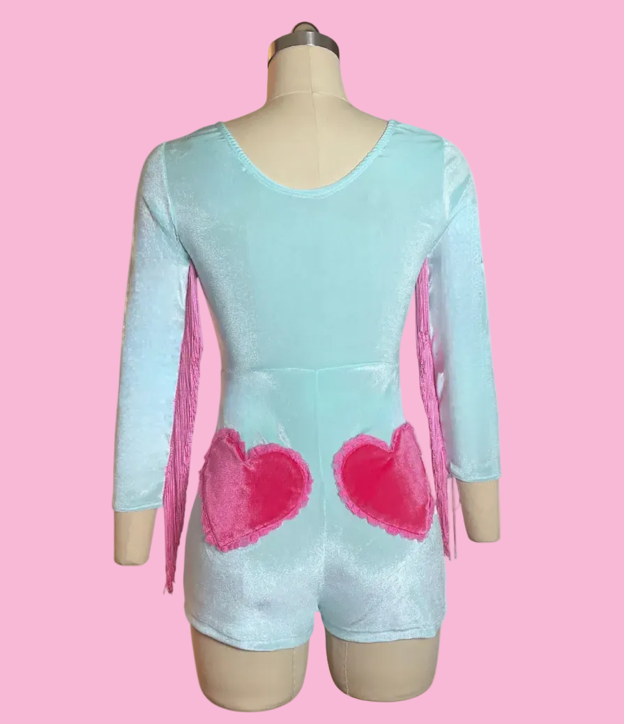 Light blue romper with pink hearts and pink fringes along the sleeves